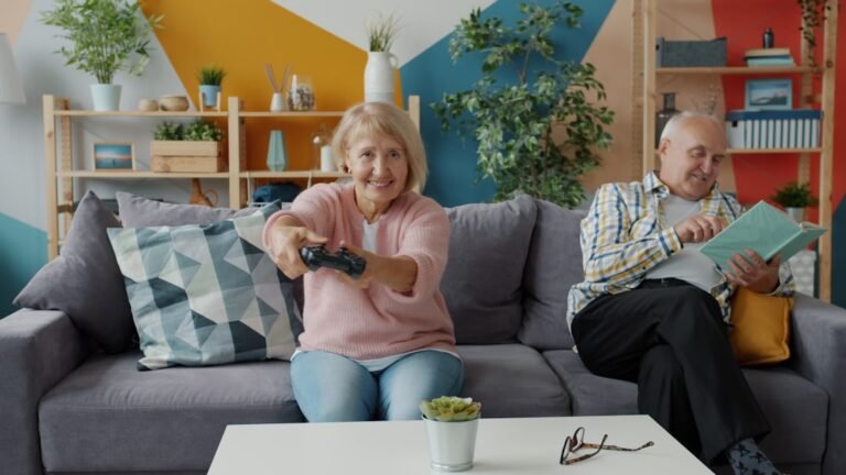 Elderly couple playing video games and reading on couch